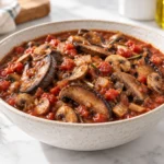 Tomato-based mushroom stew with browned portabella and white mushrooms, onion, and rosemary